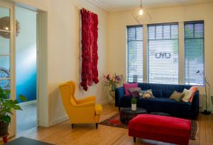a living room with a blue couch and a yellow chair at OYO rooms in Kortrijk