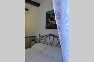 um quarto com uma cama de dossel branca em La Gianchina di Vernazza - Central Cozy Apt Wi-Fi em Vernazza