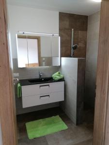 La salle de bains est pourvue d'un lavabo et d'un miroir. dans l'établissement Appartement Kaiserplatzl, à Scheffau am Wilden Kaiser