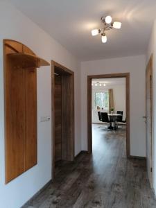 un salon vide avec des portes en bois et une salle à manger dans l'établissement Appartement Kaiserplatzl, à Scheffau am Wilden Kaiser