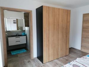 baño con lavabo y armario de madera en Appartement Kaiserplatzl, en Scheffau am Wilden Kaiser