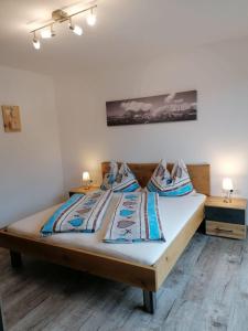 a large bed in a room with two night stands at Appartement Kaiserplatzl in Scheffau am Wilden Kaiser