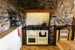a kitchen with a stove and a stone wall at Our Holiday House Yorkshire, Ingleton - children and doggy friendly in Ingleton 