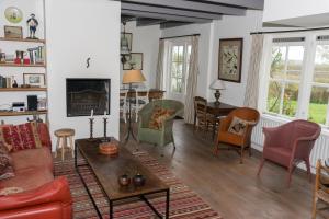 ein Wohnzimmer mit einem Sofa und Stühlen in der Unterkunft Hello Zeeland - Vakantiehuis Klakbaan 4 in IJzendijke