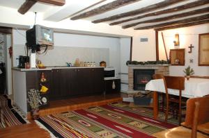 a living room with a television and a fireplace at The House in Shipka in Shipka