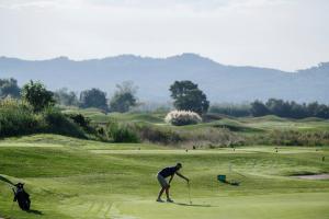 a person is playing golf on a golf course at Empordà Golf Resort in Torroella de Montgrí