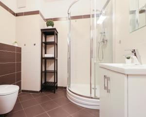 a bathroom with a shower and a toilet and a sink at Aquamarina by Baltic Home in Świnoujście