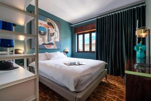 1 dormitorio con cama y pared azul en urban beach sixties, en Portimão