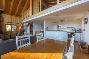 a kitchen and living room with a wooden table in a house at Chalet Asphodel in Plan Fey +16 photos