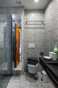 a bathroom with a toilet and a glass shower at urban beach sixties in Portimão