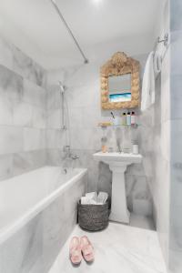 a white bathroom with a sink and a tub and a sink at VISIONAPARTMENTS Albertstrasse - self check-in in Zurich