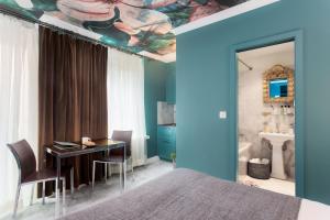 a bedroom with a bed and a table and a bathroom at VISIONAPARTMENTS Albertstrasse - self check-in in Zurich