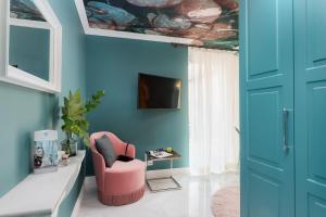 a living room with a pink chair and blue walls at VISIONAPARTMENTS Albertstrasse - self check-in in Zurich