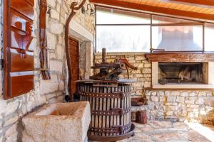 a stone room with a stone fireplace and a stove at Holiday House Karla in Krunčići