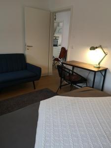 
a room with a bed, desk, chair and a lamp at Gästewohnung -kleine Auszeit- am Greifswalder Bodden in Greifswald
