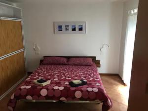 a bedroom with a bed with a red comforter at Baita Dal Vikingo in Sorico