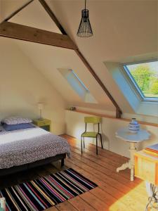 une chambre avec un lit, une table et une fenêtre dans l'établissement La maison du pêcheur, à Saint-Quay-Portrieux