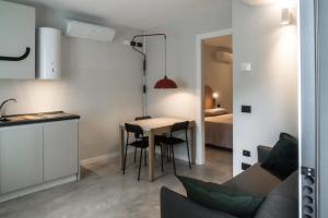 a kitchen and a living room with a table and a couch at WelcomeVerona in Verona