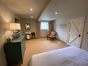 a bedroom with a bed and a desk and a door at Rectory Farm Barn in Grantham