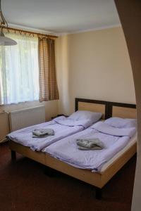 a bedroom with two beds with towels on them at Pensjonat 4 Pory roku in Duszniki Zdrój