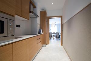 a kitchen with wooden cabinets and a microwave at Goodnight Cádiz Apartments in Cádiz
