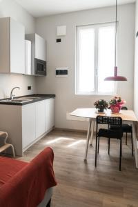 uma pequena cozinha com uma mesa e um lavatório em WelcomeVerona em Verona