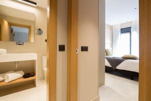 a bedroom with a bed and a bathroom with a mirror at Goodnight Cádiz Apartments in Cádiz