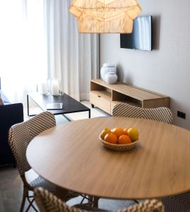 a dining room table with a bowl of fruit on it at Goodnight Cádiz Apartments in Cádiz