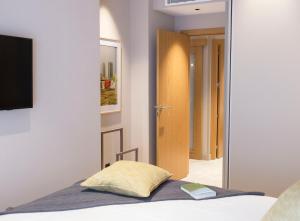 a bedroom with a bed with a yellow pillow at Goodnight Cádiz Apartments in Cádiz