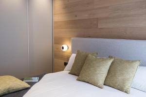 a bedroom with a white bed with a wooden headboard at Goodnight Cádiz Apartments in Cádiz