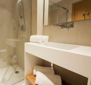 a bathroom with a white sink and a shower at Goodnight Cádiz Apartments in Cádiz
