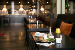 a table with a plate of food and a glass of orange juice at ProfilHotels Savoy in Jönköping