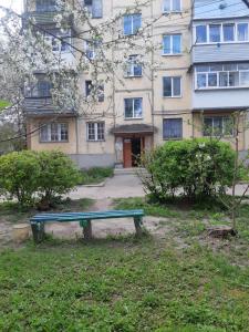 eine grüne Bank vor einem Gebäude in der Unterkunft Очень уютная, тихая, єко комната с видом на сад in Winnyzja