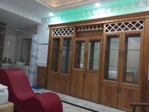 Cette chambre dispose d'un grand meuble en bois et d'une chaise rouge. dans l'établissement Amor Hotel, à Hô-Chi-Minh-Ville