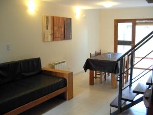 - un salon avec un canapé et une table à manger dans l'établissement Posada El Jarillal, à Sierra de la Ventana