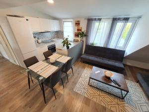 a kitchen and a living room with a table and chairs at Good times apartmán in Žilina