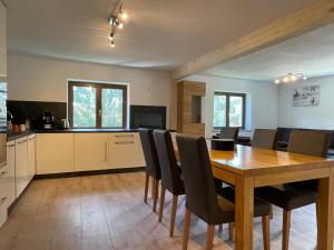 a kitchen and dining room with a wooden table and chairs at Apartments Garden House in Niedernsill