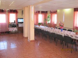 a long table in a room with chairs and flowers at Pensiunea Ando in Bran