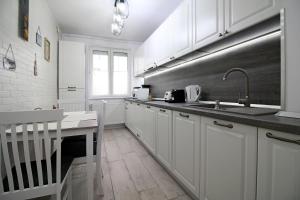 a kitchen with white cabinets and a sink at White Stone in Sibiu