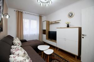 a living room with a couch and a tv at White Stone in Sibiu