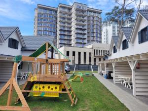 einen Spielplatz in einem Hof neben einem Gebäude in der Unterkunft Domki HORYZONT in Dziwnówek