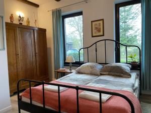 - une chambre avec un lit et une grande fenêtre dans l'établissement PUJSZANY AGROTURYSTYKA, à Skierbieszów