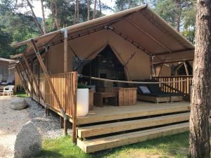 a large tent with a porch and a tree at AZUR Camping Wertheim in Wertheim