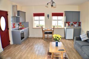 een keuken en een woonkamer met een bank en een tafel bij Sea Breeze in Doolin