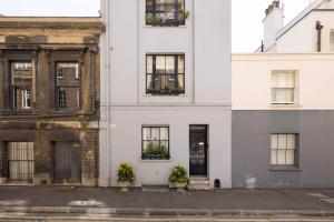 a white building with potted plants on the windows at Spacious, Light-Filled 2 Bedroom Apartment in London