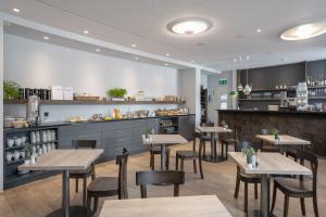a restaurant with tables and chairs and a counter at Boutique Hotel St. Georg in Einsiedeln