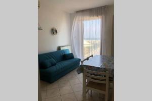 ein Wohnzimmer mit einem blauen Sofa und einem Tisch in der Unterkunft Al Mare apartment in Chioggia