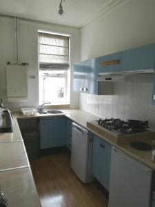 a kitchen with blue cabinets and a stove top oven at Sunrise in Walton-on-the-Naze