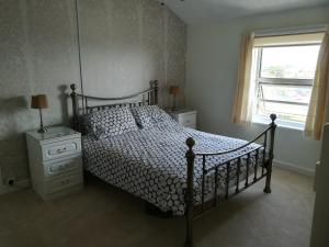 Schlafzimmer mit einem Bett und einem Fenster in der Unterkunft Sunrise in Walton-on-the-Naze