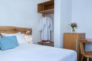 1 dormitorio con 1 cama y 1 albornoz colgado en un estante en Hotel Galini, en Firostefani